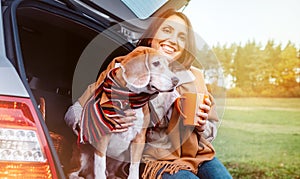 Woman with dog sit together in cat truck and warms Ãâ ÃËÃÂµÃâ¬ hot tea. Auto travel with pets concept image photo